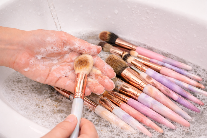 Lavage à la main des pinceaux maquillage dans un évier